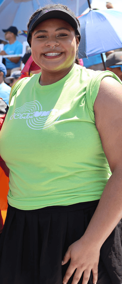 Zora Williams wearing a black skirt and a bright green t shirt that says community