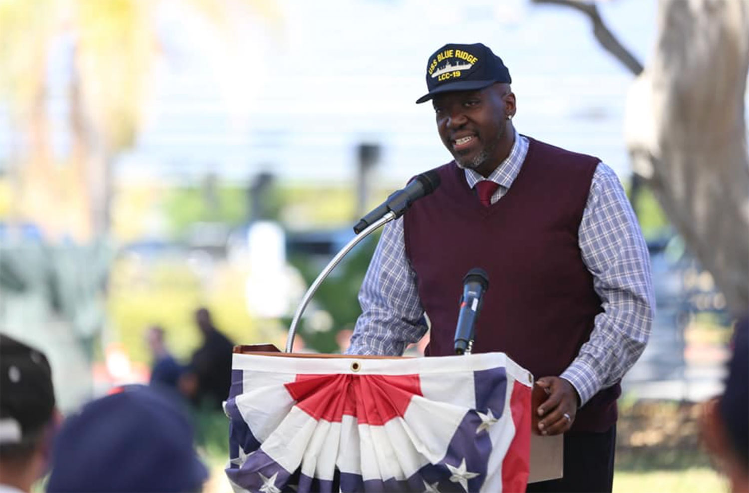 Andre Harris speaking at a podium at a Veterans Day event