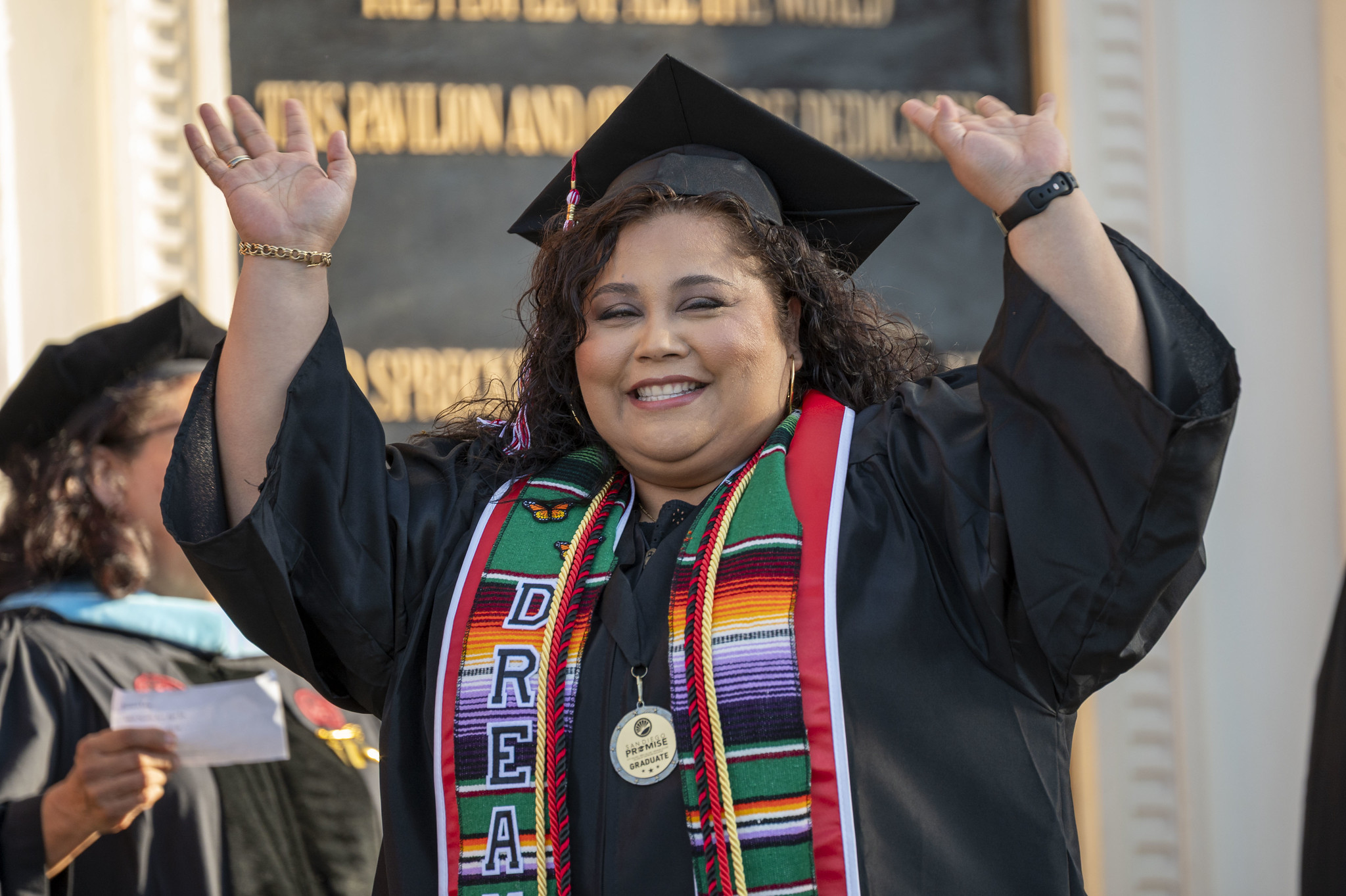 
A student cheering as she walks on stage to receive her degree.
