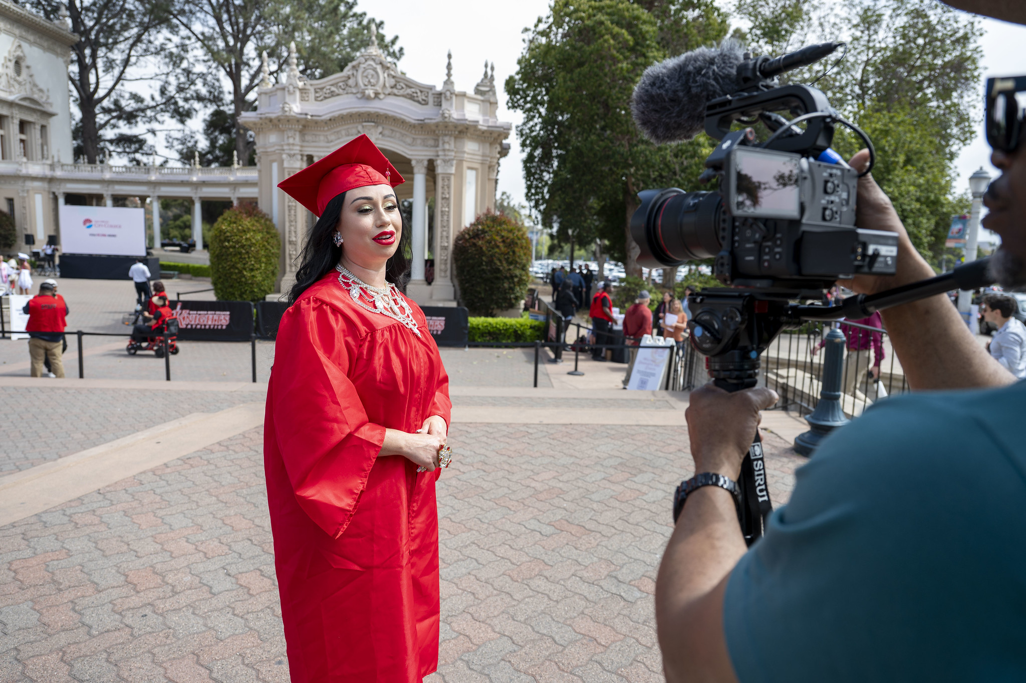 
A graduate in a red cap and gown.
