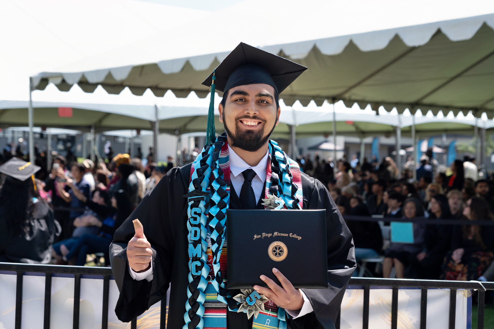 
A student holds up his degree.
