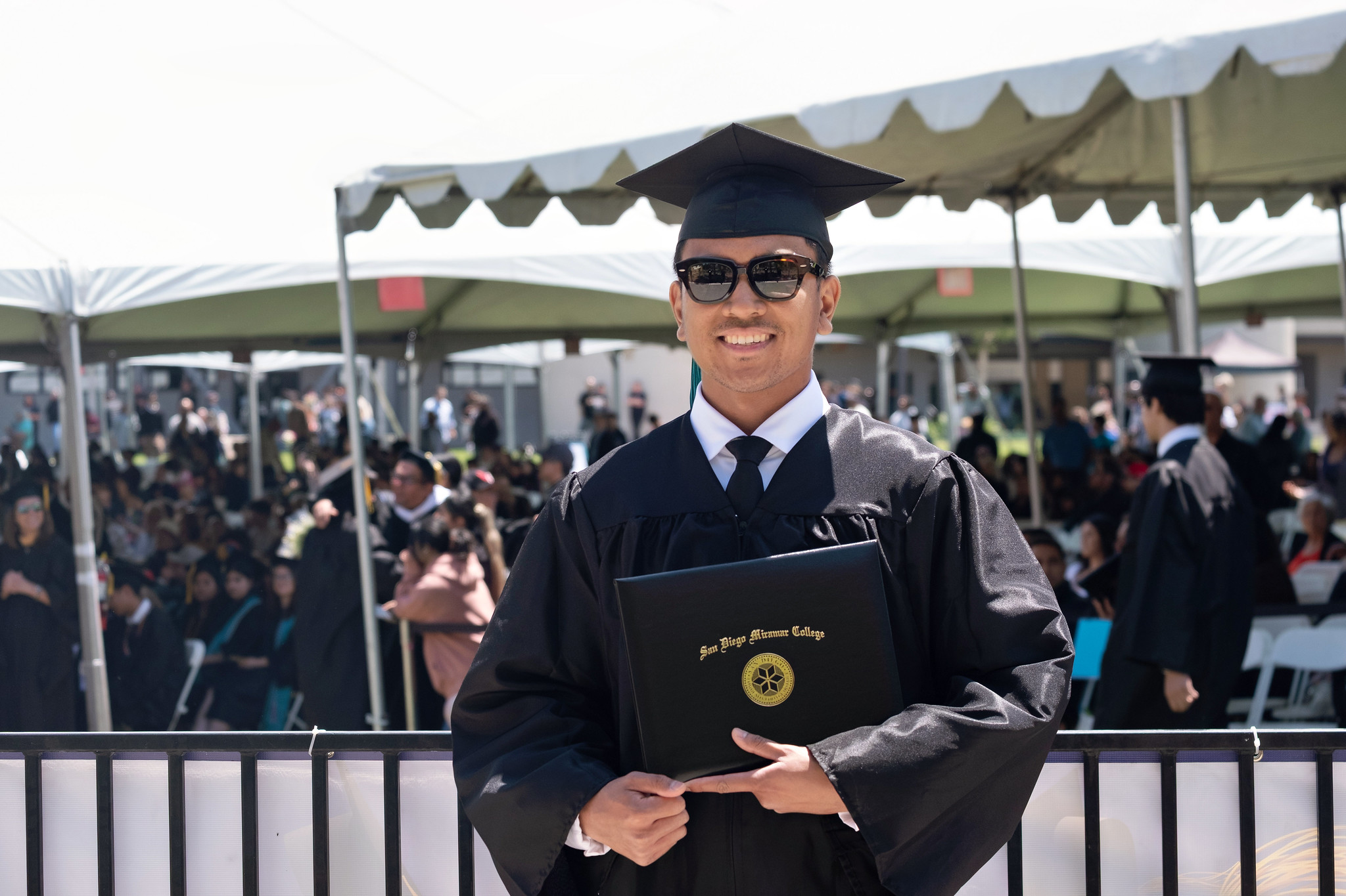 
A student holds up his degree.

