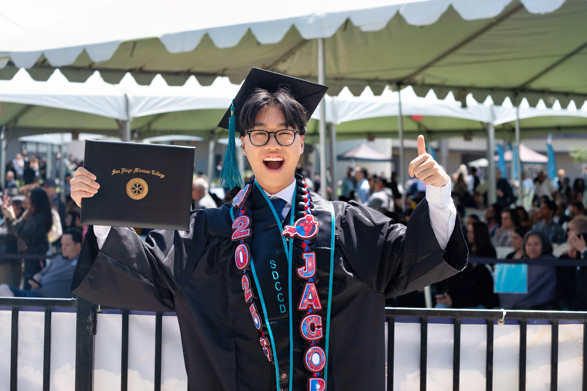 
A graduate is holding up his degree.
