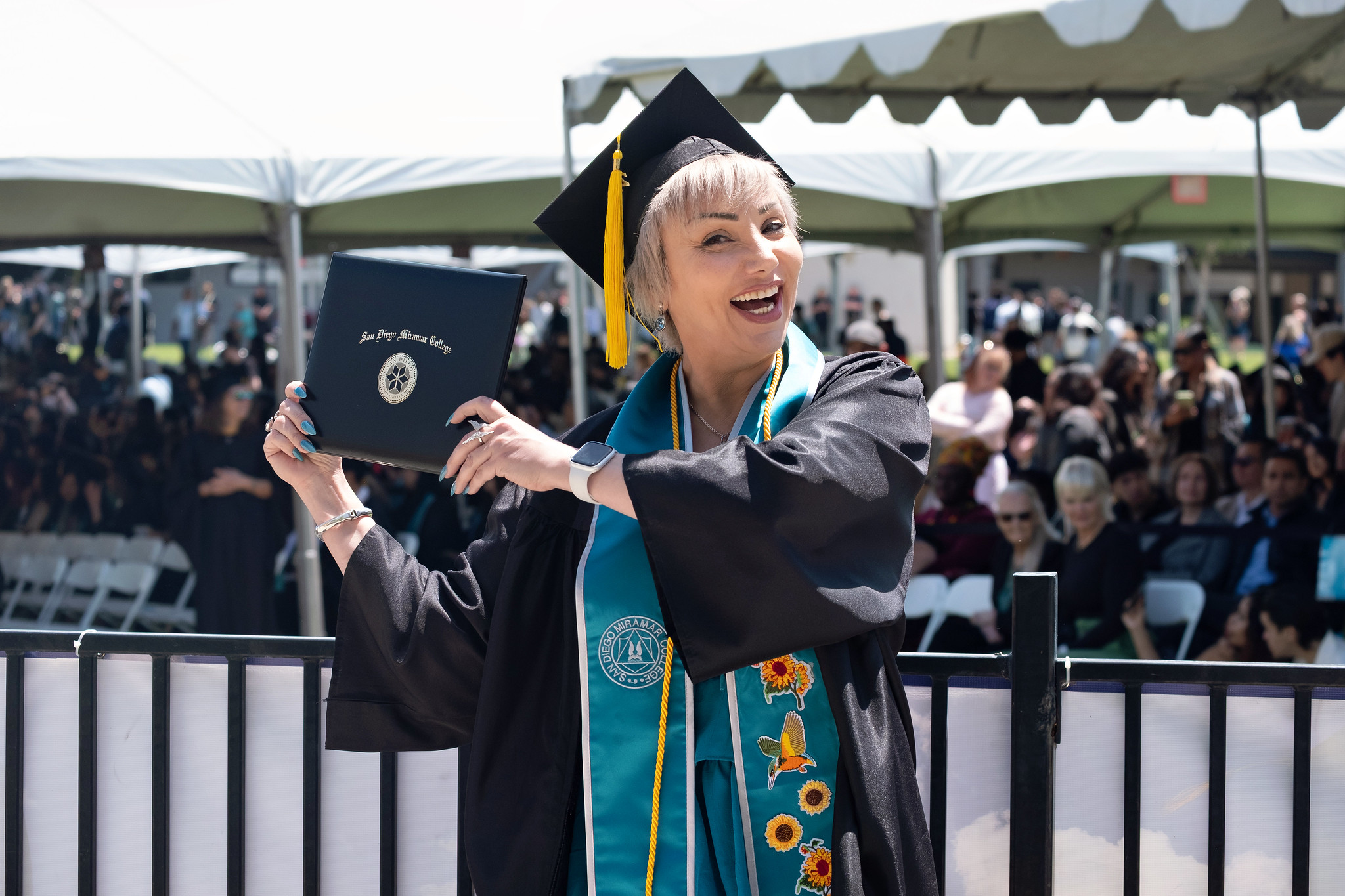 
A graduate holds up her degree.

