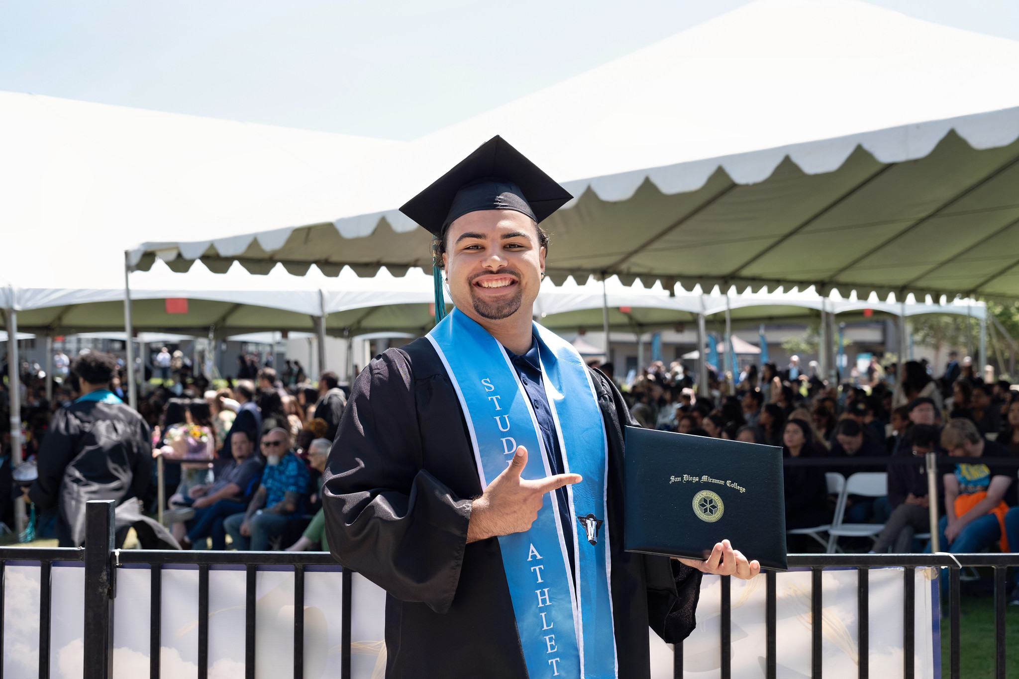 
A graduate holds up his degree.
