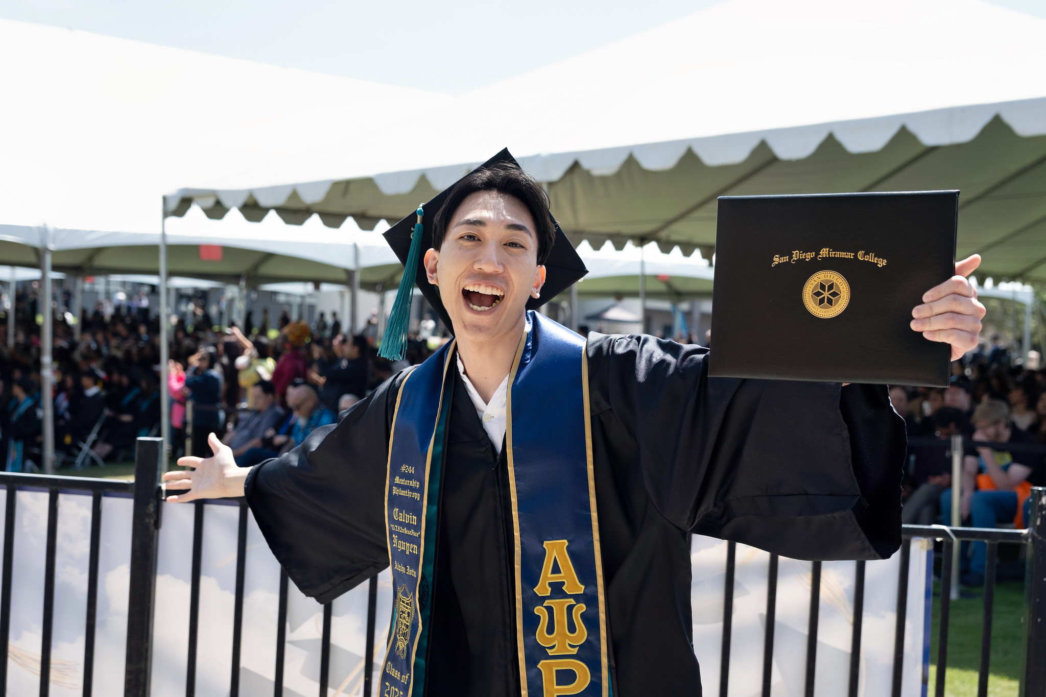 
A graduate holds up his degree.
