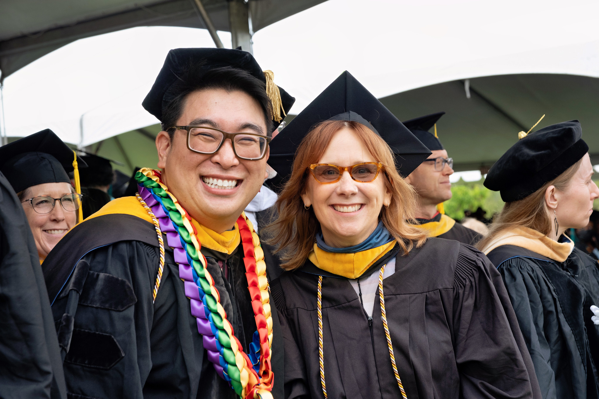 
Two faculty members in caps and gowns at commencement.
