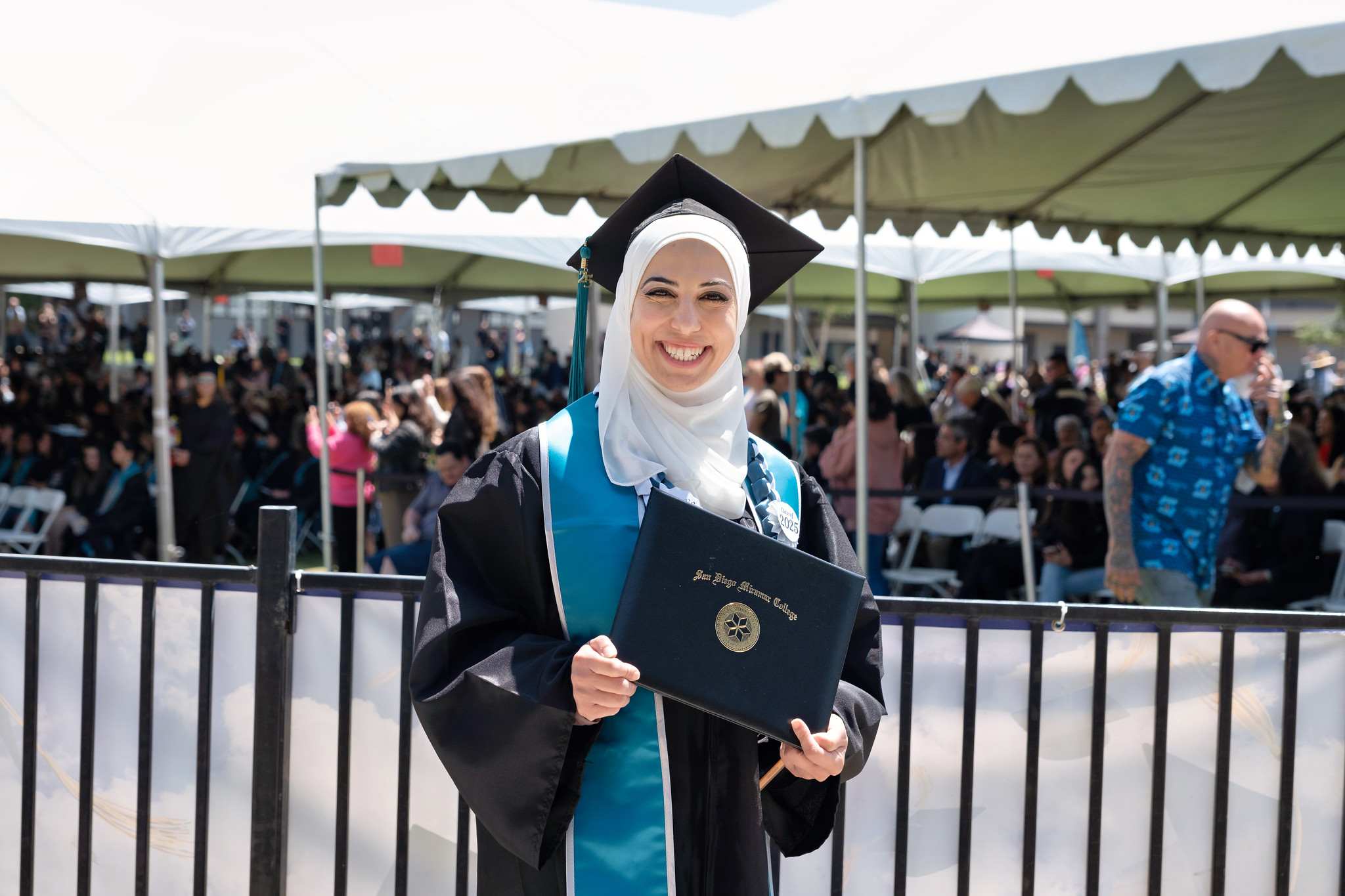 
A graduate holds up her degree.
