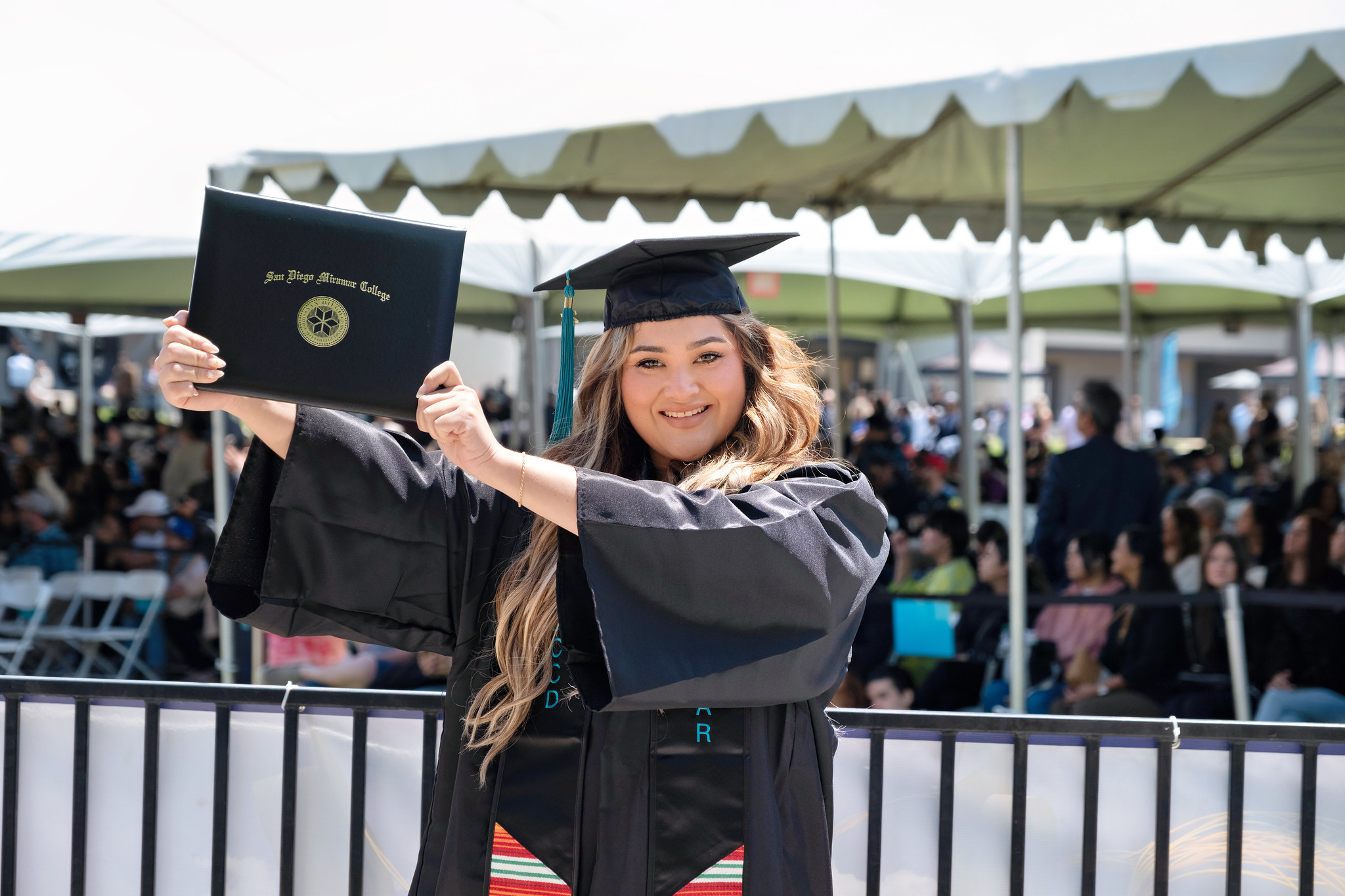 
A graduate holds up her degree.
