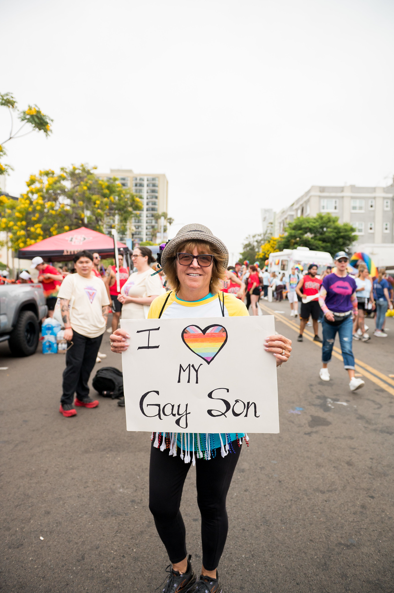 
A woman holds a sign that says I love my gay son.
