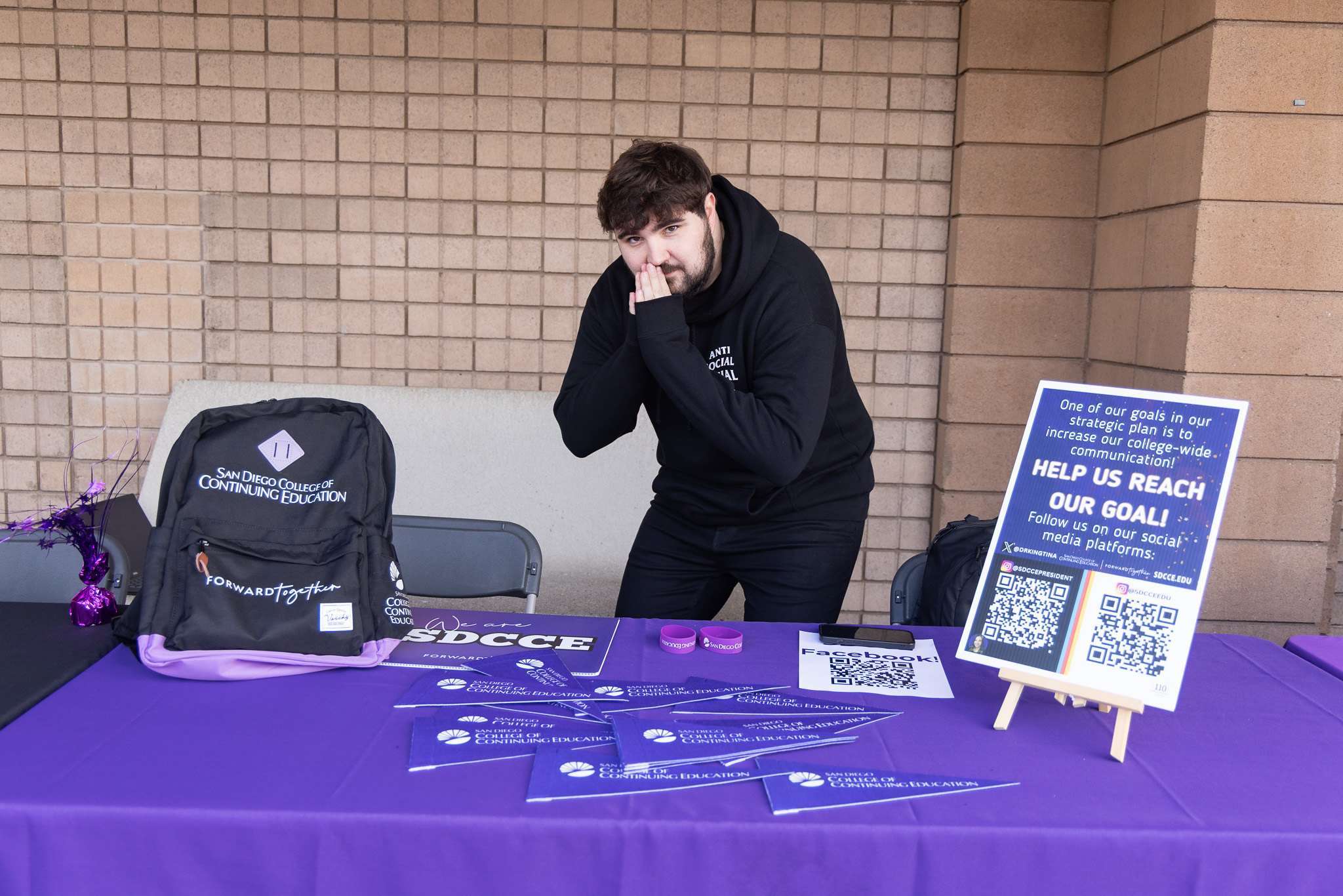 
An employee at a Continuing Education welcome table.
