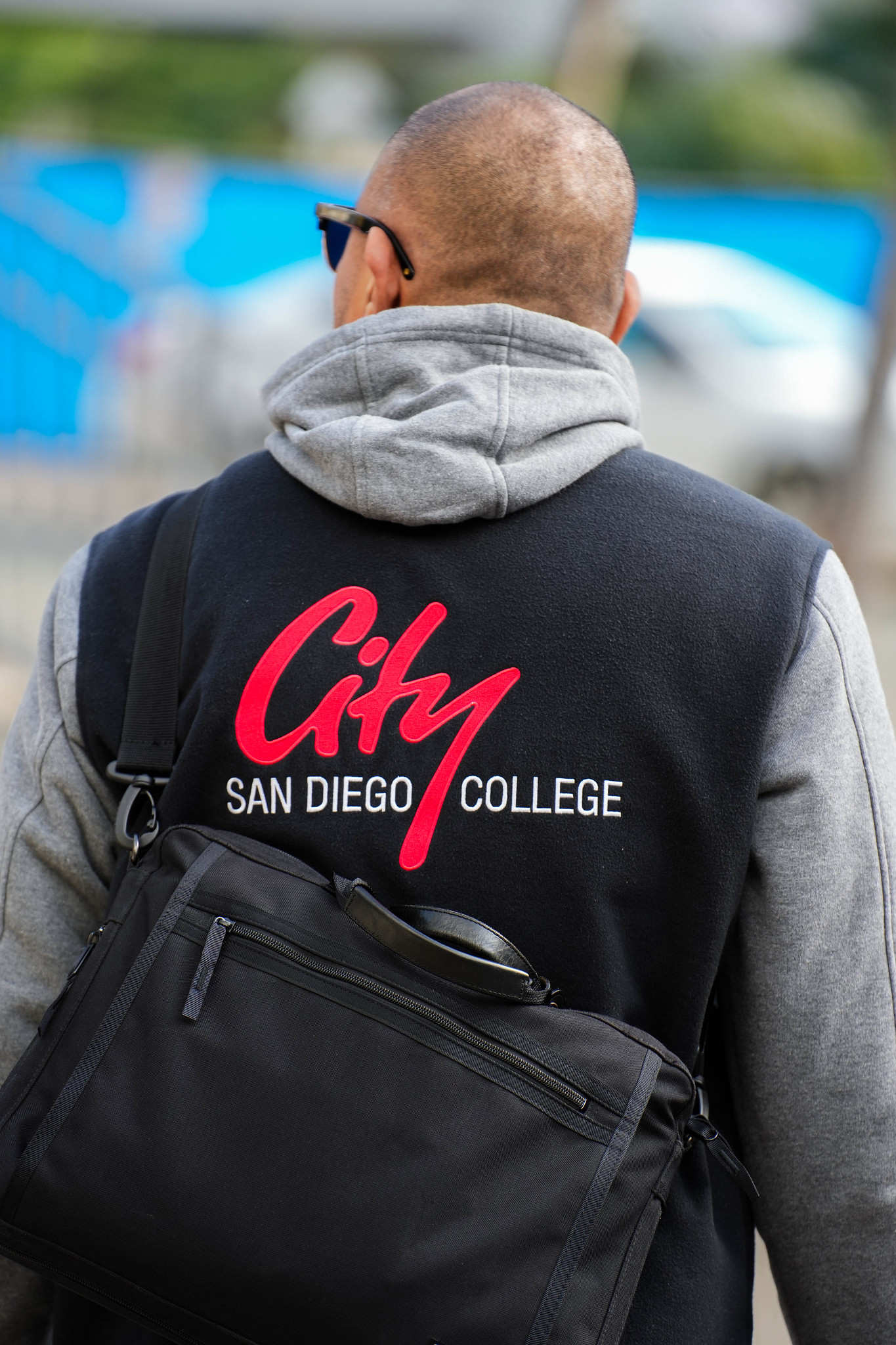 
A man wearing a jacket with City College's logo.
