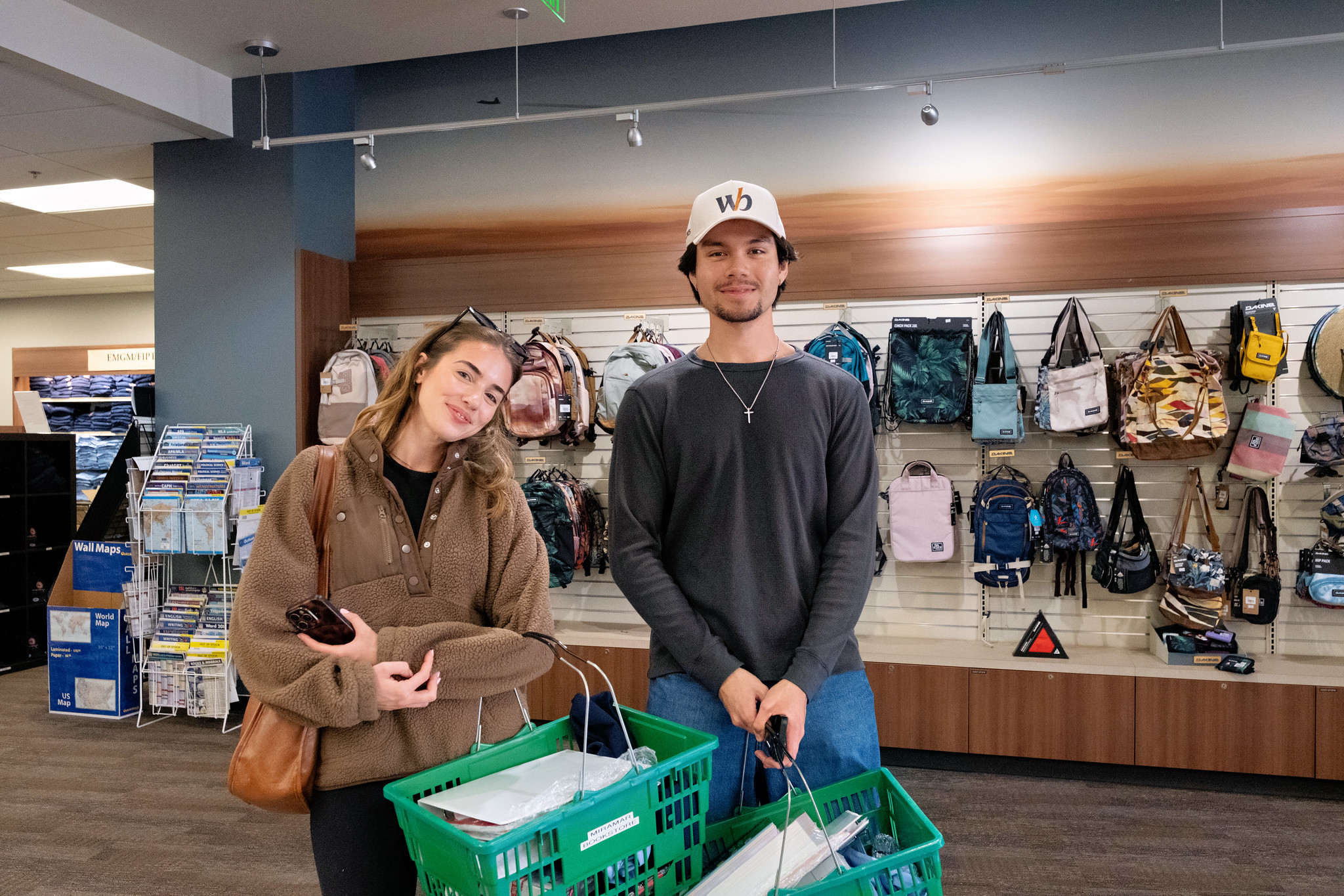 
Two students with hand-held shopping baskets at the Miramar bookstore.
